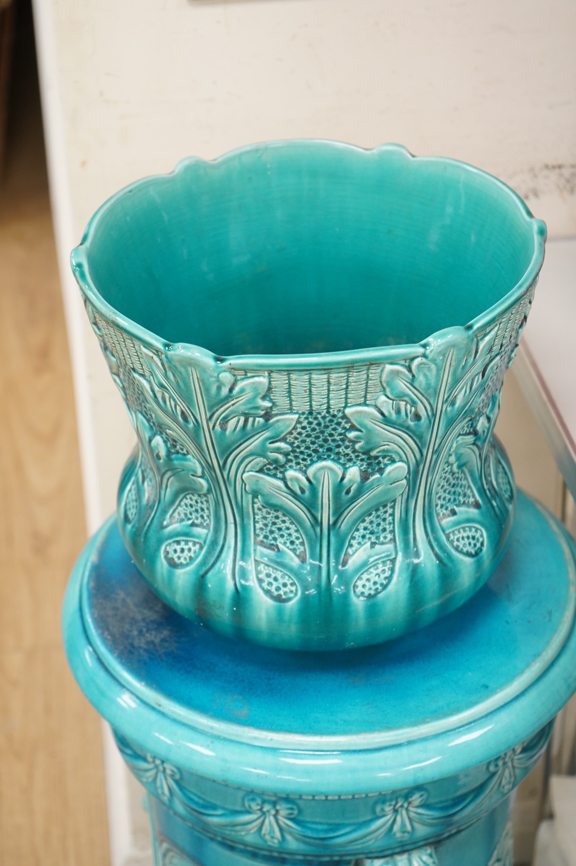 A Burmantofts style turquoise glazed jardiniere and a similar larger stand, decorated in relief, 90cm high